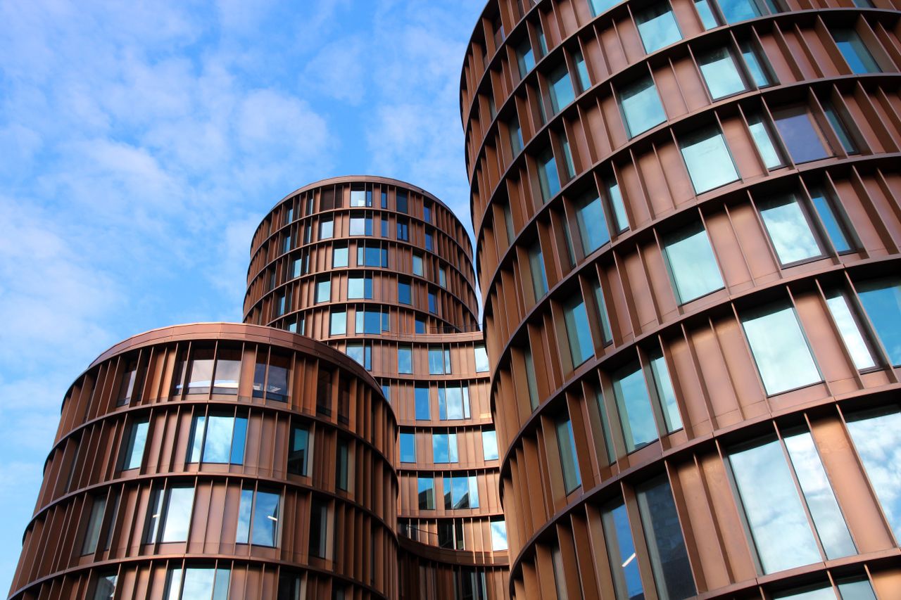 Home Striking modern architecture showcasing cylindrical glass buildings with reflecting windows against a vibrant blue sky.